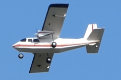 John Wase flies his Britten-Norman Islander on a summer evening. Model was built from an American plan designed by Bud Chappel, 60” wingspan, covered in Oratex. Power is by two 3530 1100kV motors swinging 9x4” counter-rotating props. Two 30A ESCs fed by a 4S 4000 LiPo. Photo by Grahame Pearson, August 2025